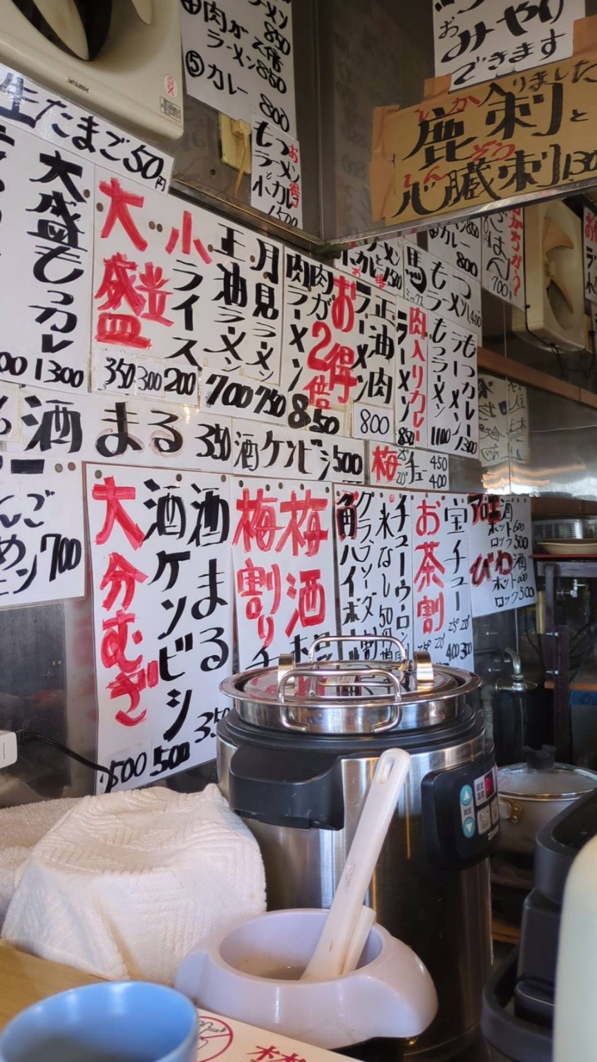 手書きの品書きがびっしり並ぶ店内の壁